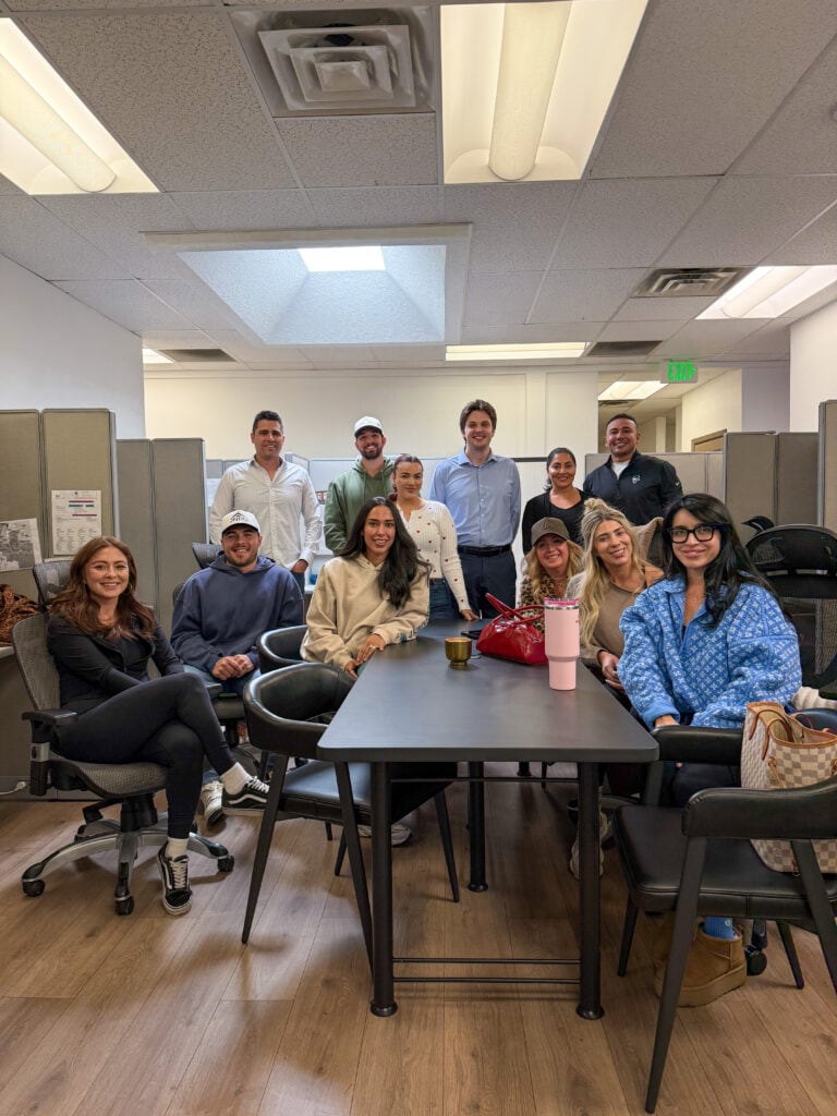 A comprehensive team of real estate professionals gathered in a modern office space, ready to assist clients with property transactions and investments.