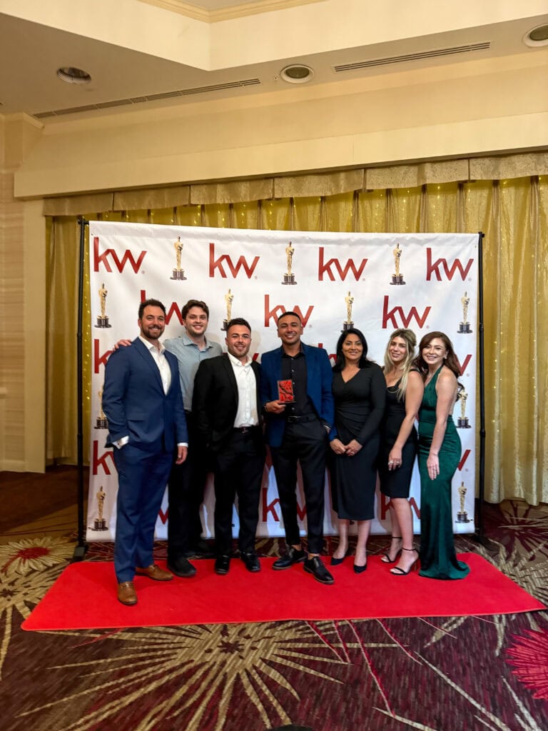 Achieve your real estate goals with Jeremy Navarro Realty Group, showcasing a professional team at a KW event, emphasizing expertise, teamwork, and success in property transactions.